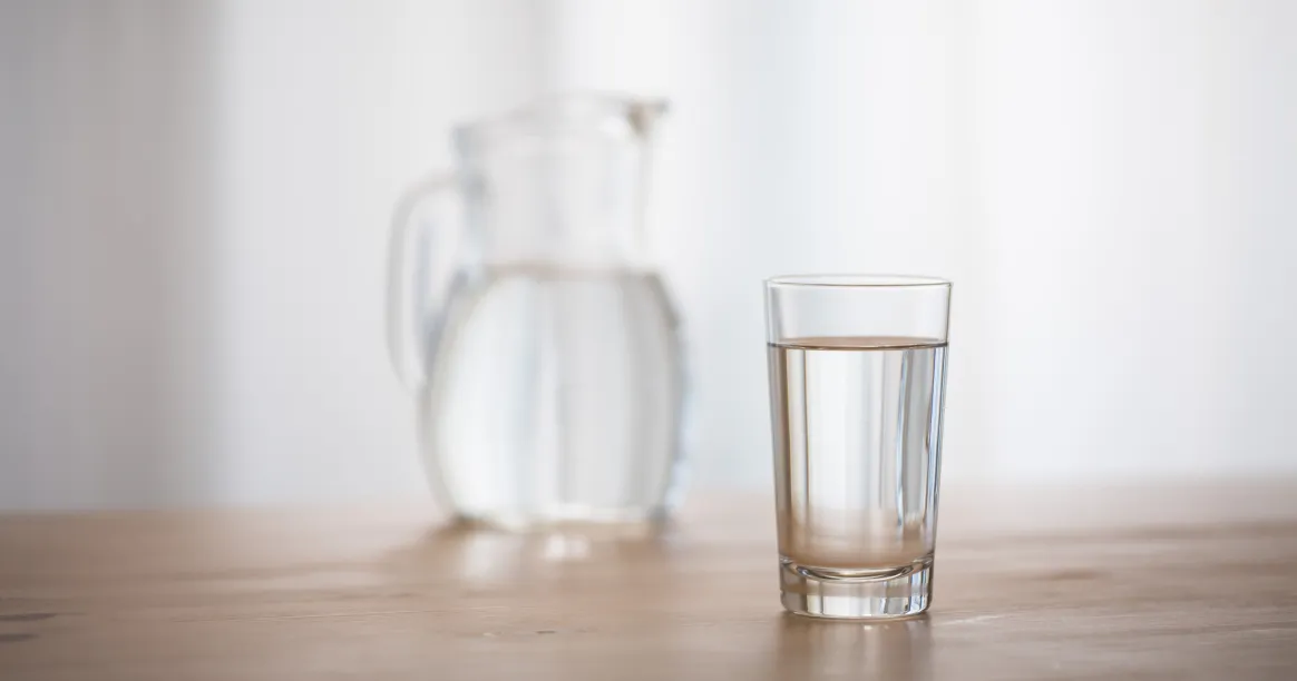 Woman drinking water during intermittent fasting to stay hydrated and avoid dehydration mistakes