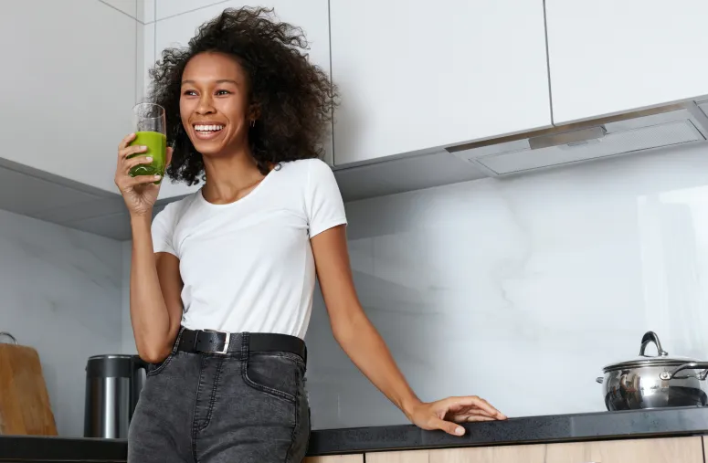 Person drinking green juice wondering if it breaks intermittent fasting window and affects ketosis state