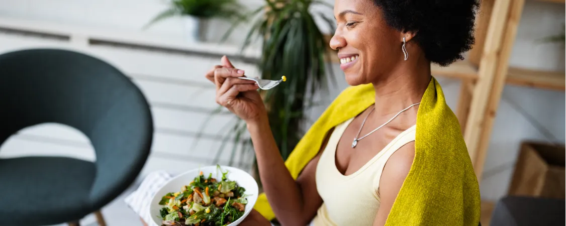 Woman eating colorful healthy salad for effective intermittent fasting weight loss