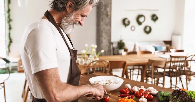 Man preparing healthy vegetables understanding how intermittent fasting impacts testosterone and men's health