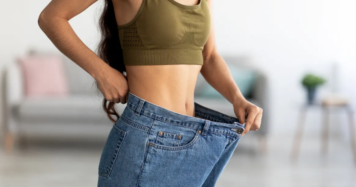 Person celebrating weight loss success after intermittent fasting transformation journey