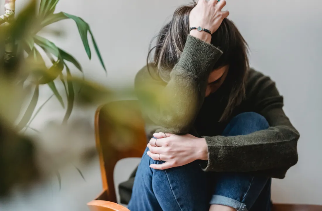 Woman experiencing headache during intermittent fasting with clock showing fasting hours
