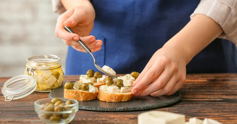 Colorful Mediterranean diet snacks including olives, nuts, fruits, and Greek yogurt arranged on a rustic wooden table
