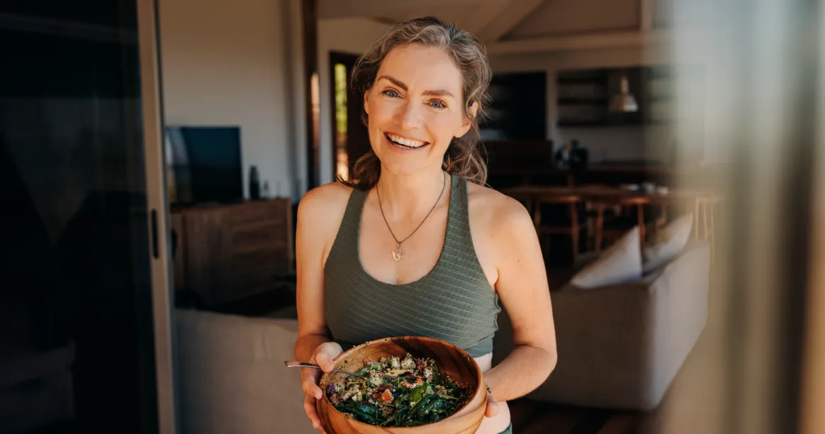 Woman holding healthy salad exploring the science and health benefits of intermittent fasting lifestyle