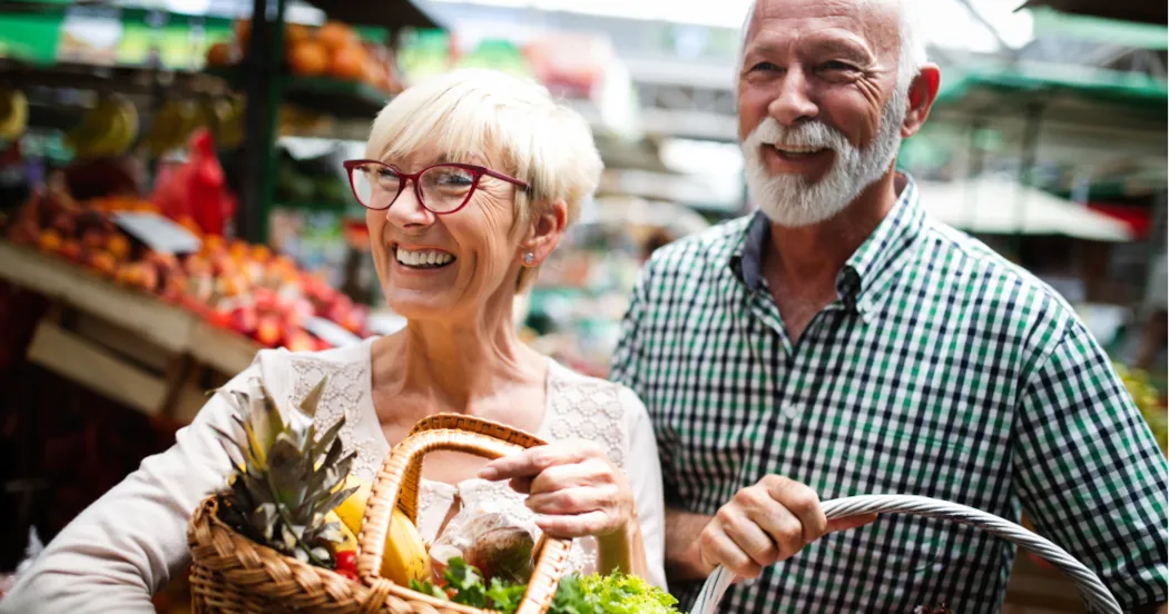 Woman shopping for healthy foods with grocery cart, selecting nutritious items for intermittent fasting meal planning